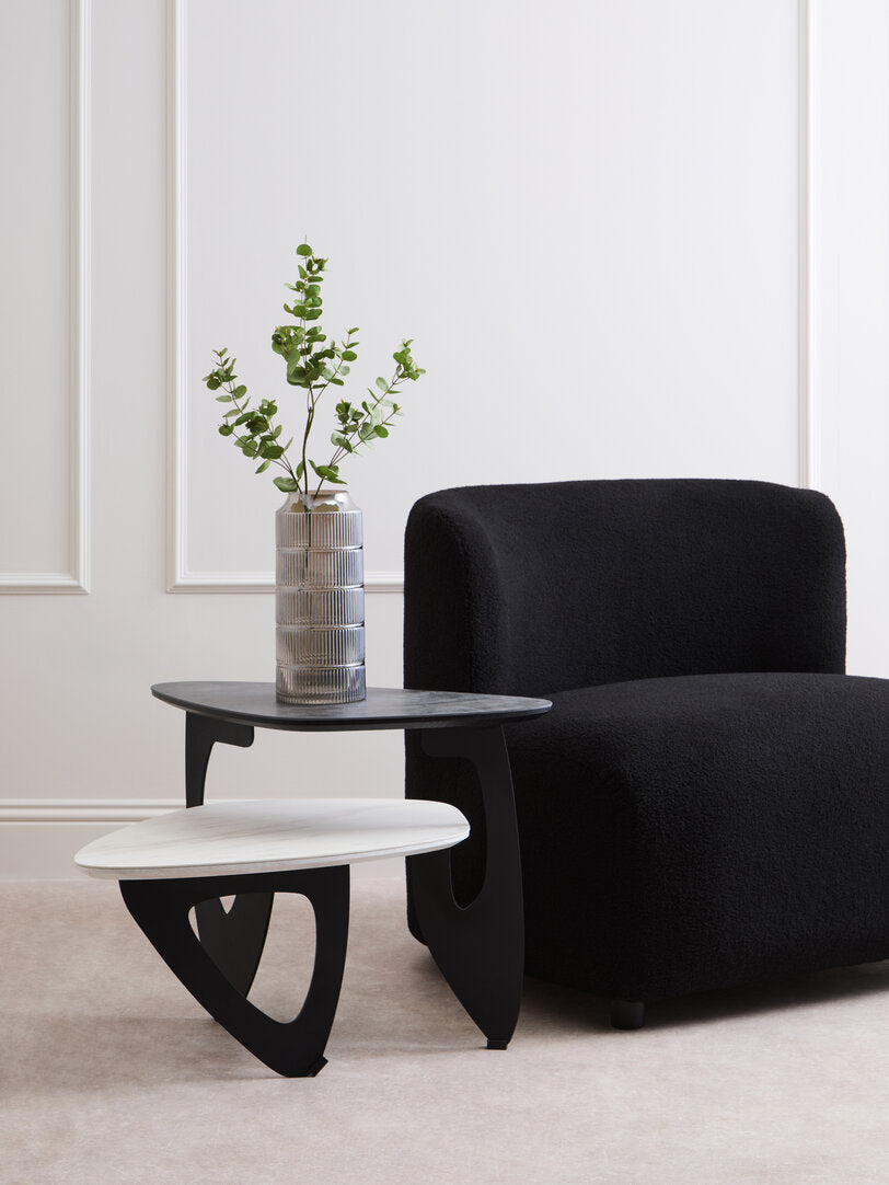 2 Tier Coffee Table with black and white tops with vase next to black armchair 