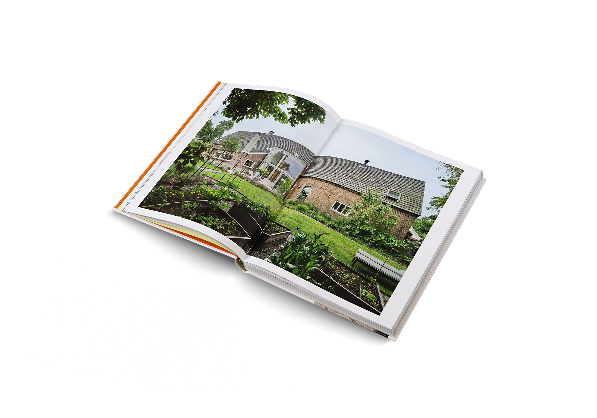 "Open book showing a photograph of a house with a garden on a white background"