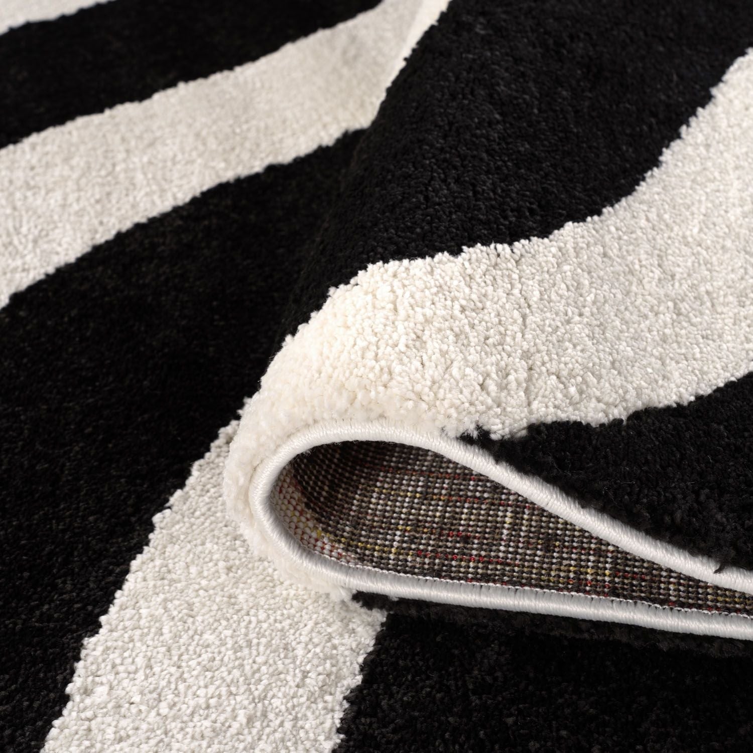 "Close-up of a black and white striped rug with a textured border."