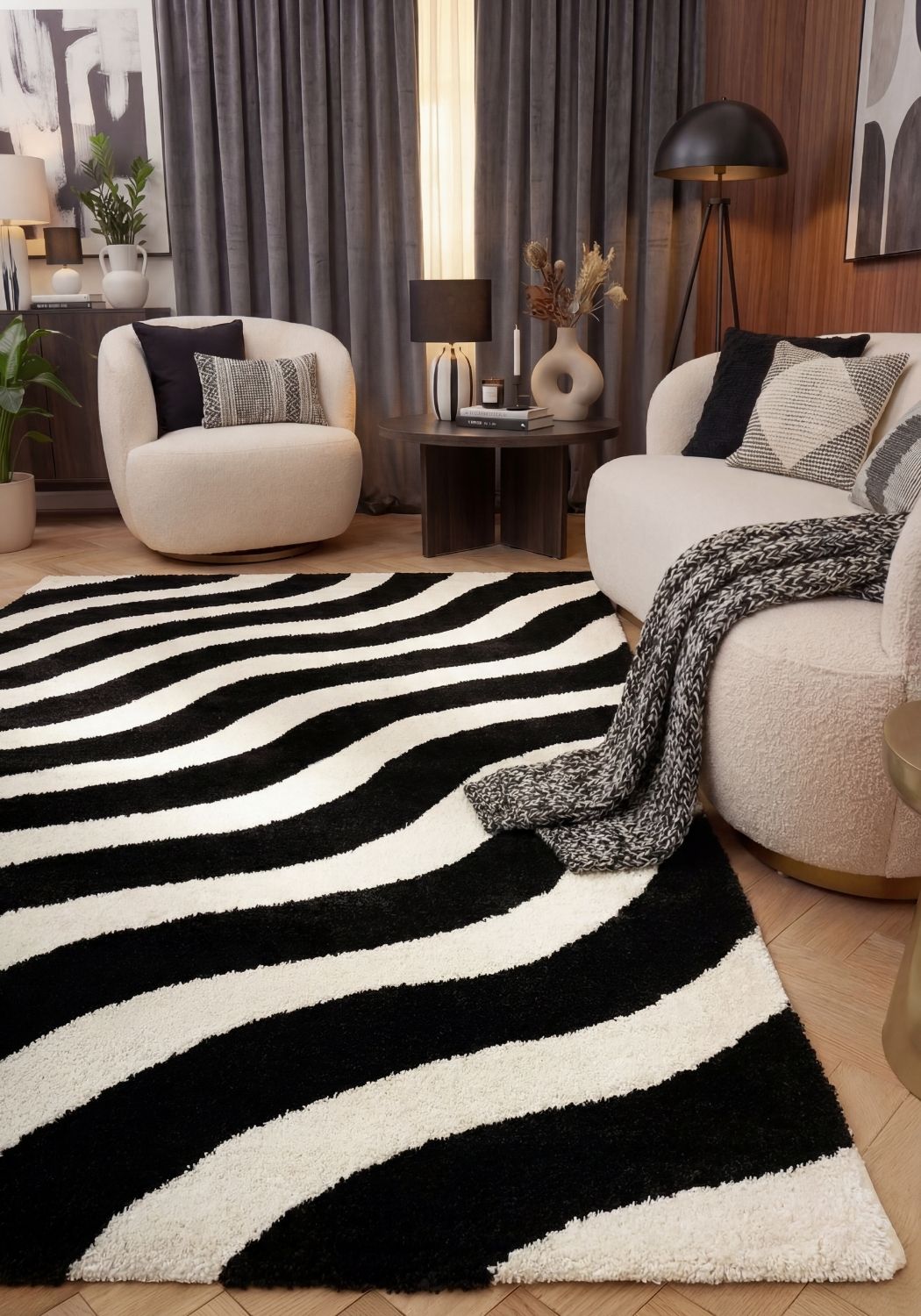 Living room with a black and white striped rug, white sofa, and decorative items.