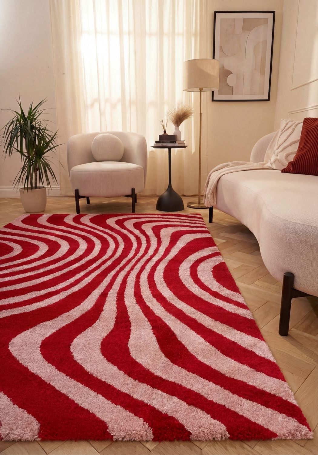 Living room with a red and pink wavy patterned rug, white sofa, and armchair.