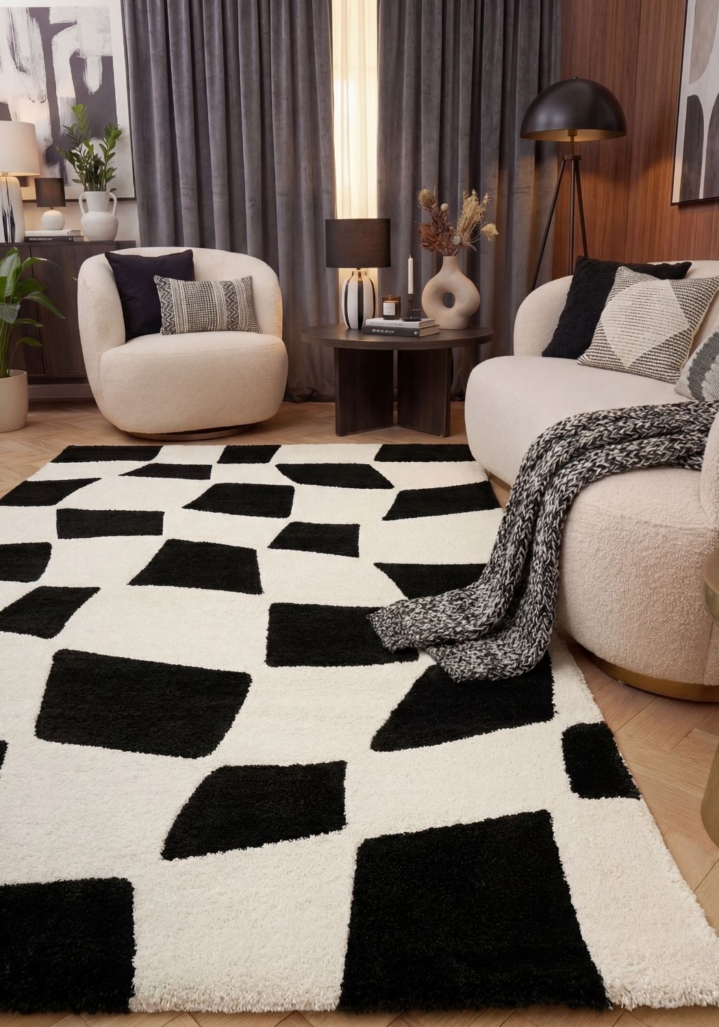 Living room with a black and white geometric rug, beige armchairs, and decorative elements.