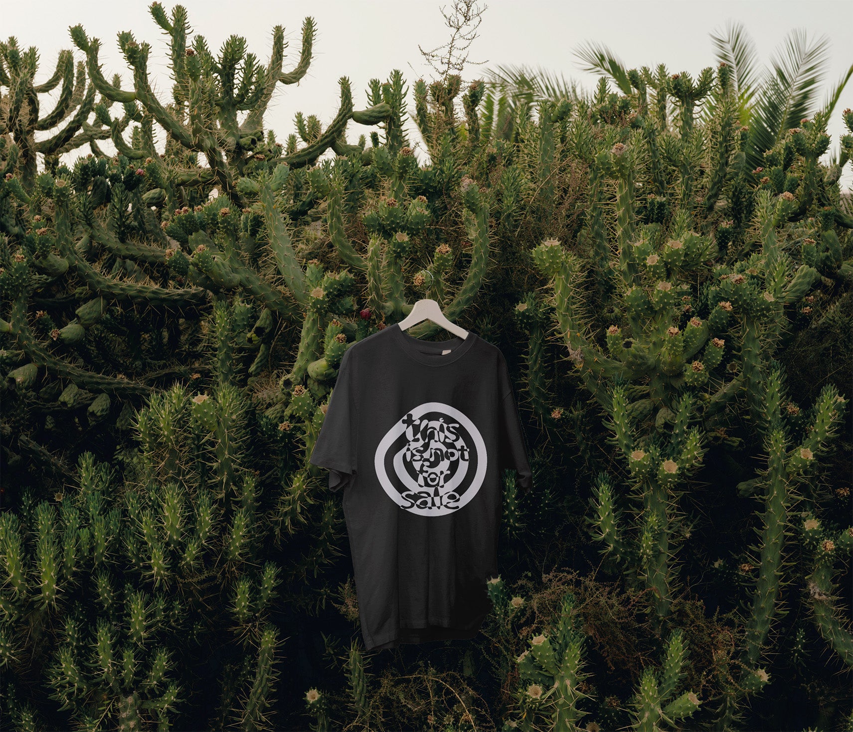 Black T-Shirt with white This is not for sale artwork by Kefino hanging in trees