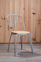 Metal chair with wooden seat against a wooden paneled wall