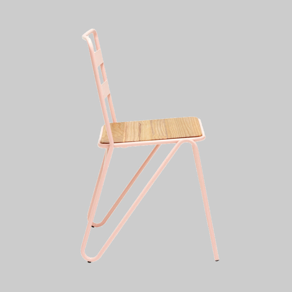 Chair with pink metal frame and wooden seat on a gray background