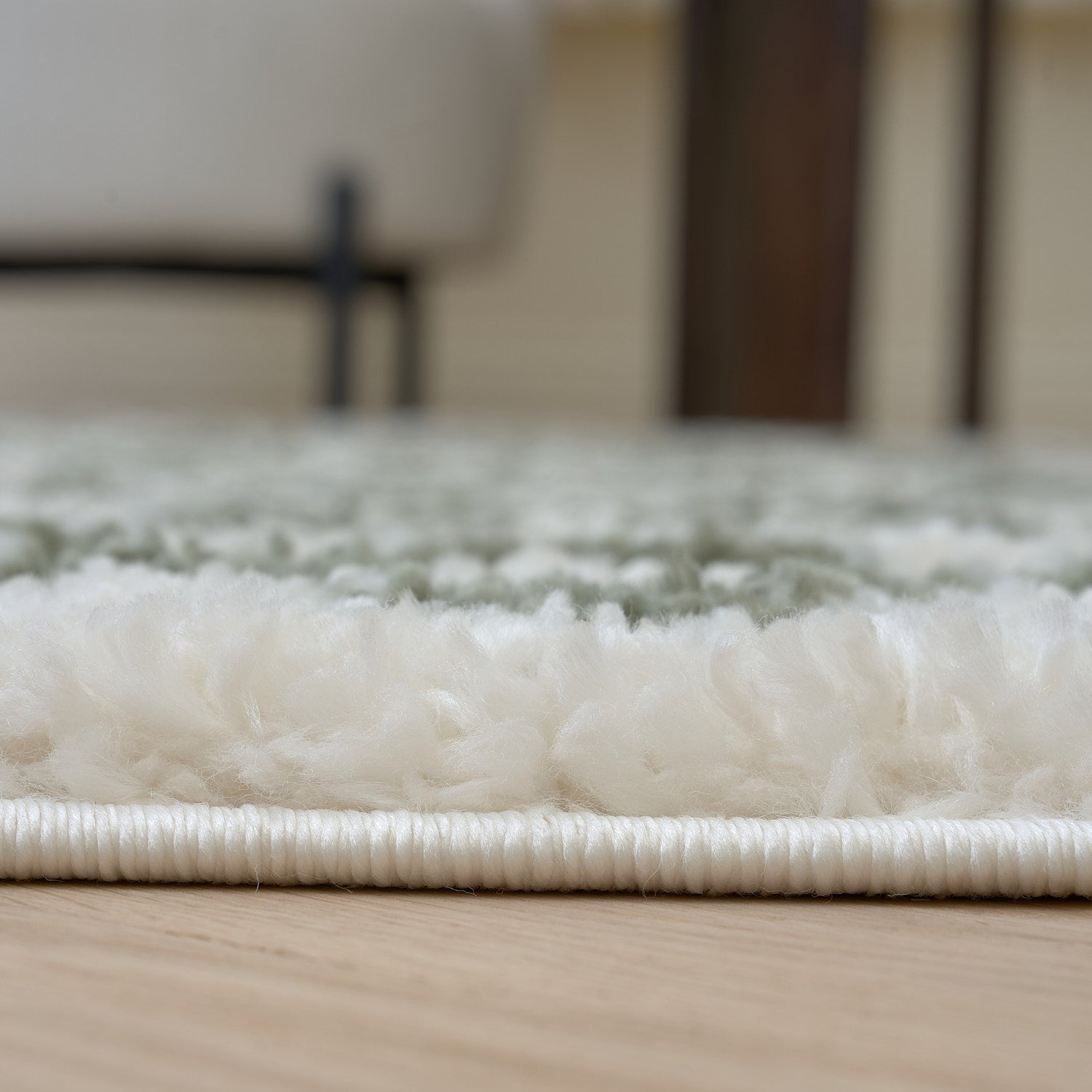 Close-up of a textured rug on a wooden floor with a blurred background