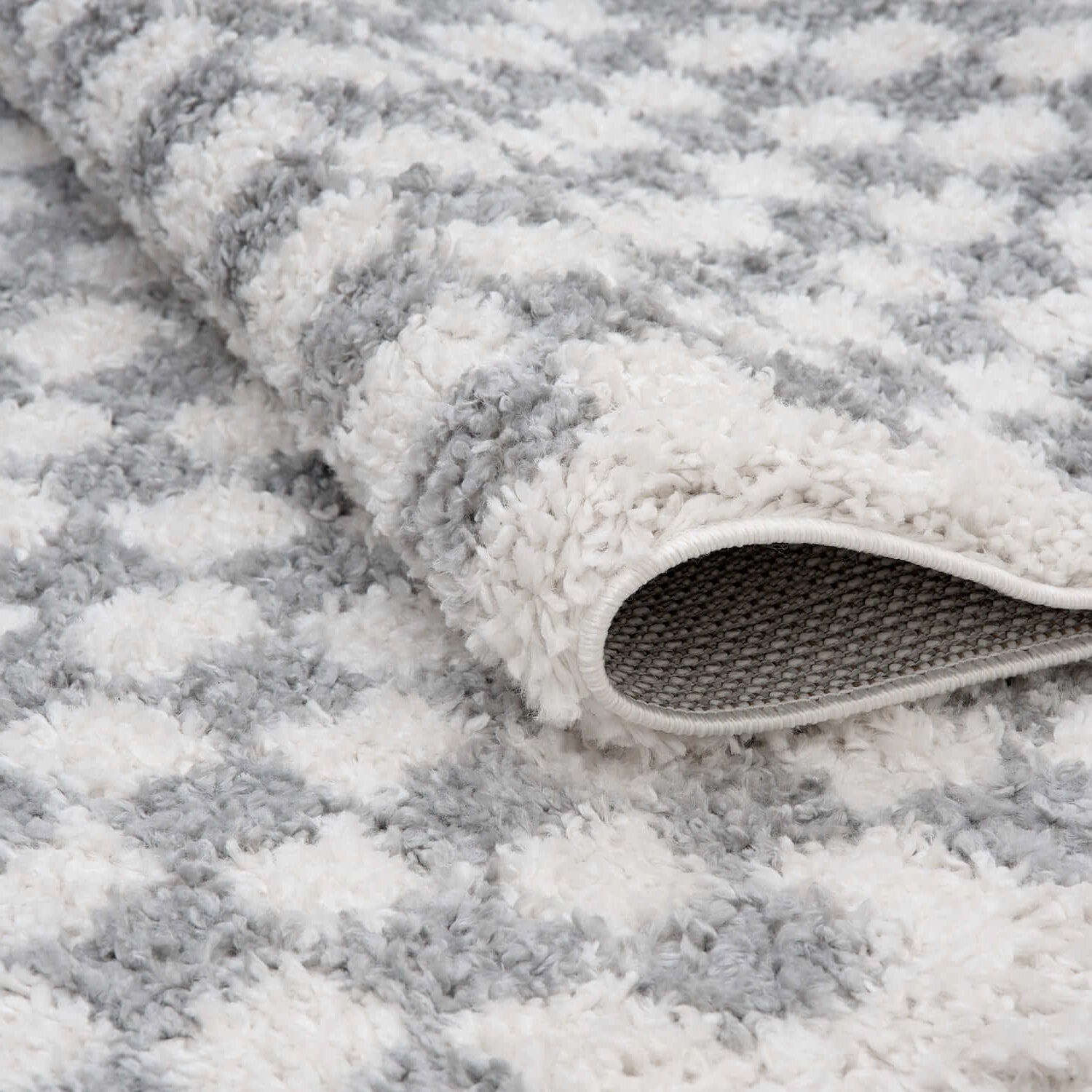 Close-up of a textured gray and white rug with a slight sheen.