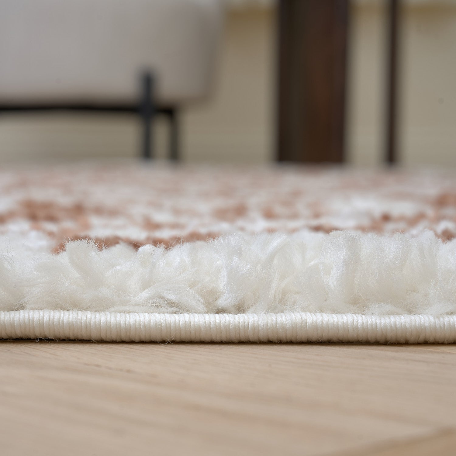 Close-up of a textured rug on a wooden floor with a blurred background