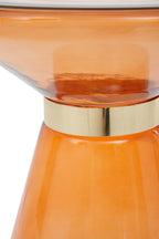 Close-up of an orange glass table with a gold base on a white background