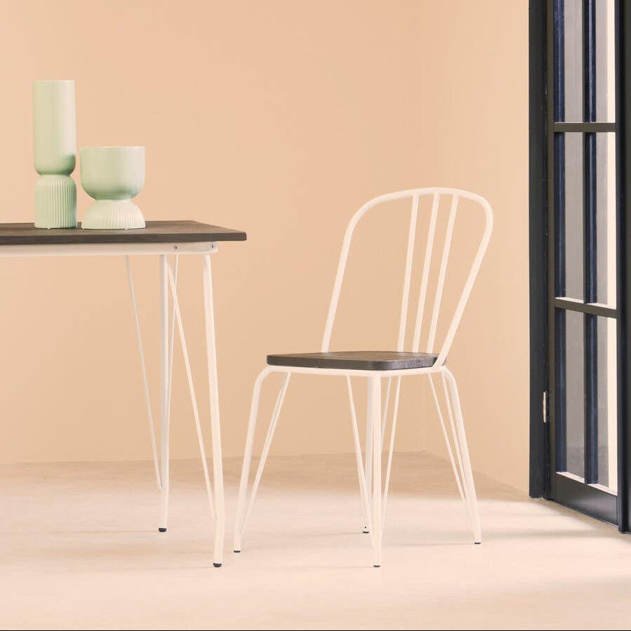White chair and small table against a beige wall with a window.