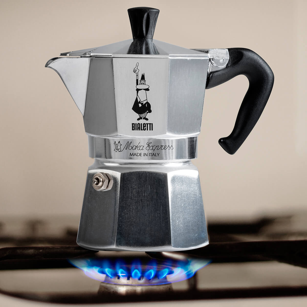Bialetti Moka Express coffee maker on a stove with a blurred background