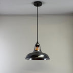 Pendant light fixture hanging from a ceiling against a plain background