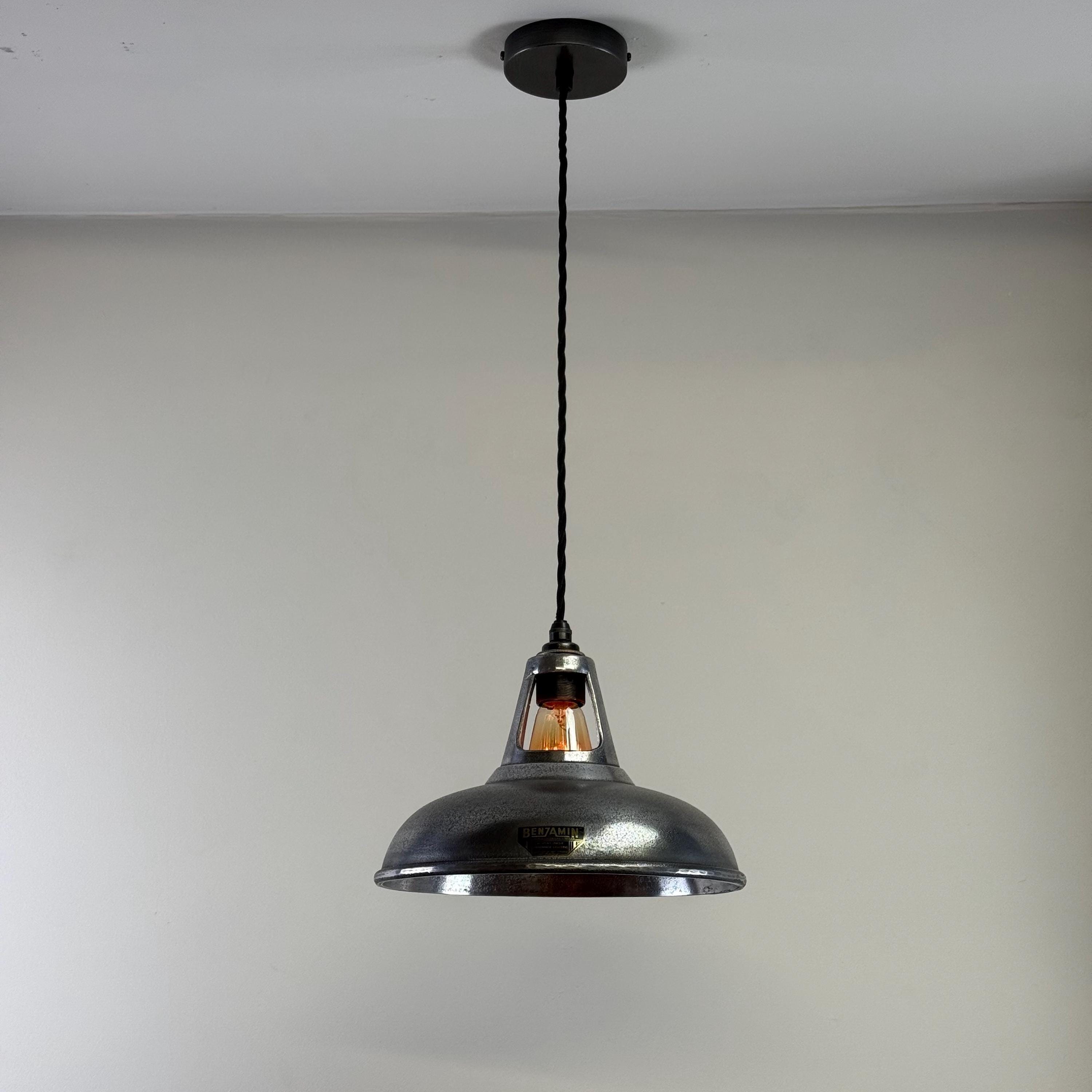 Pendant light fixture hanging from a ceiling against a plain background