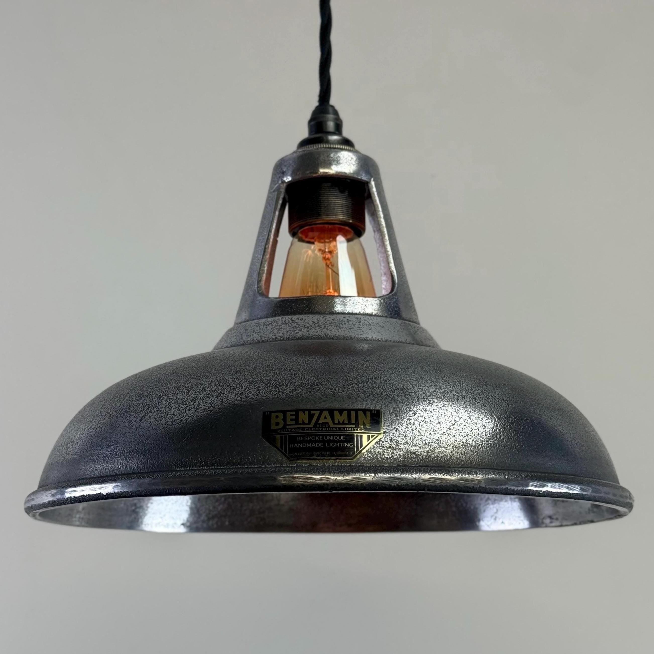 Industrial-style pendant light with a visible brand name on a grey background