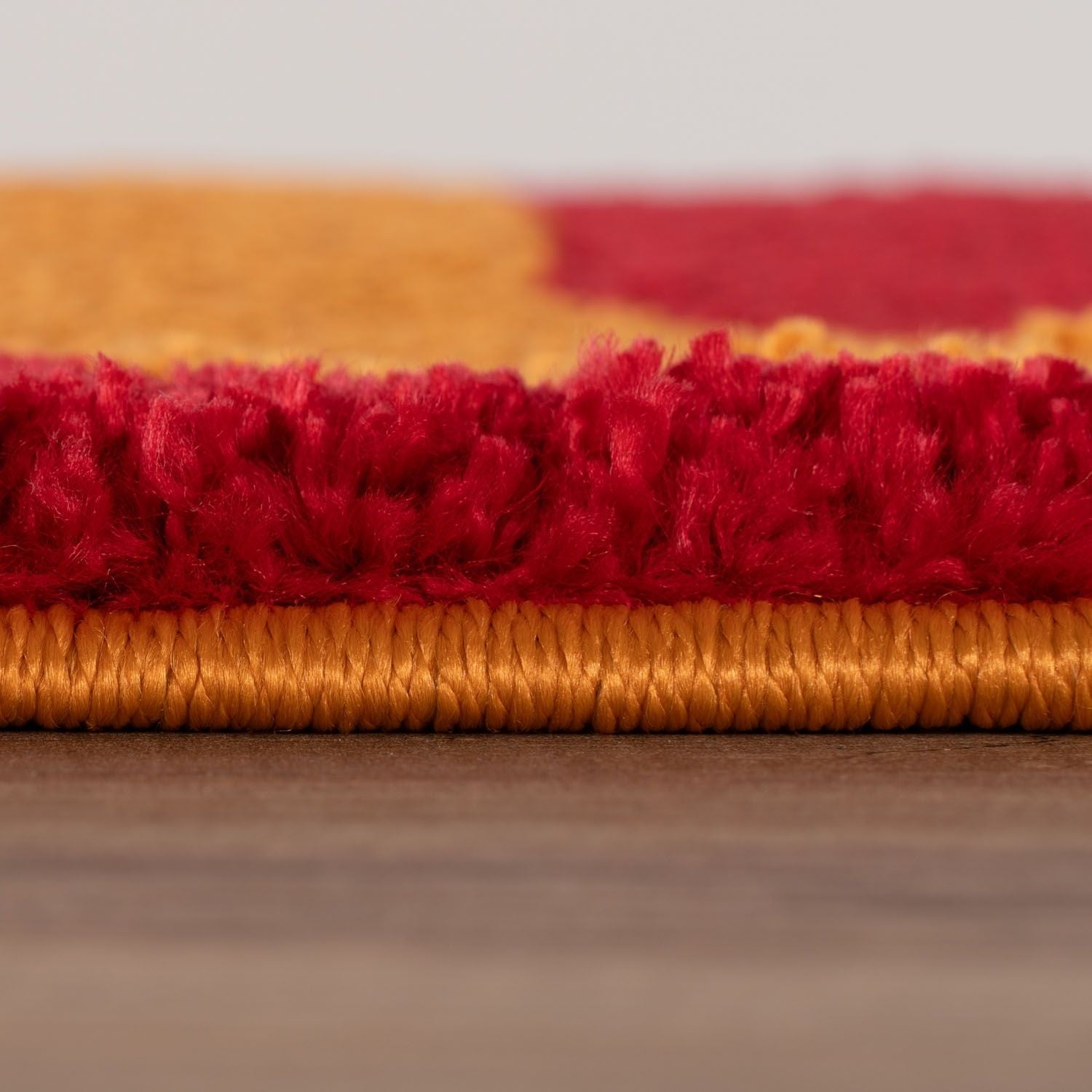 Close-up of red and orange textured fabric on a wooden surface
