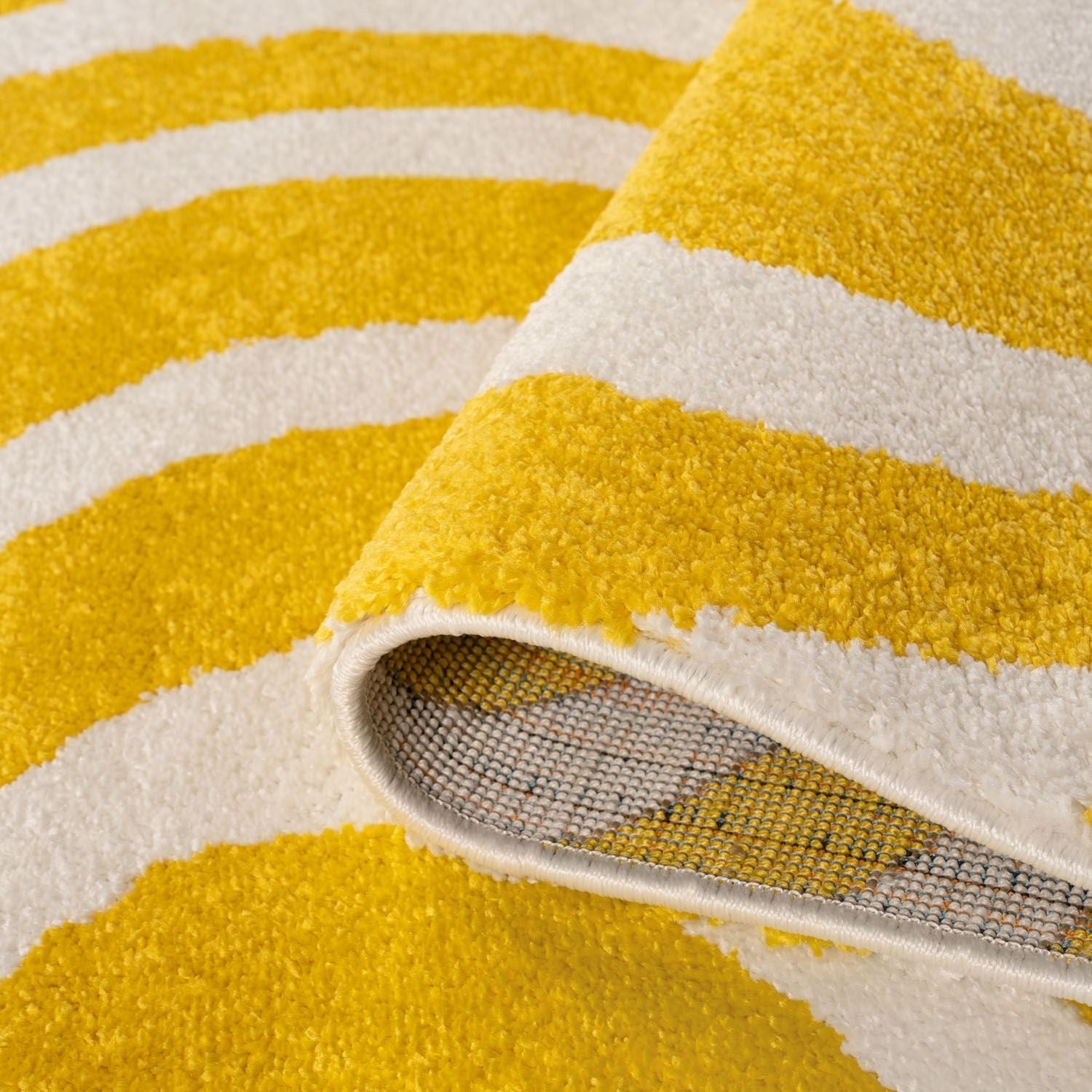 Close-up of a yellow and white striped rug with a textured surface.