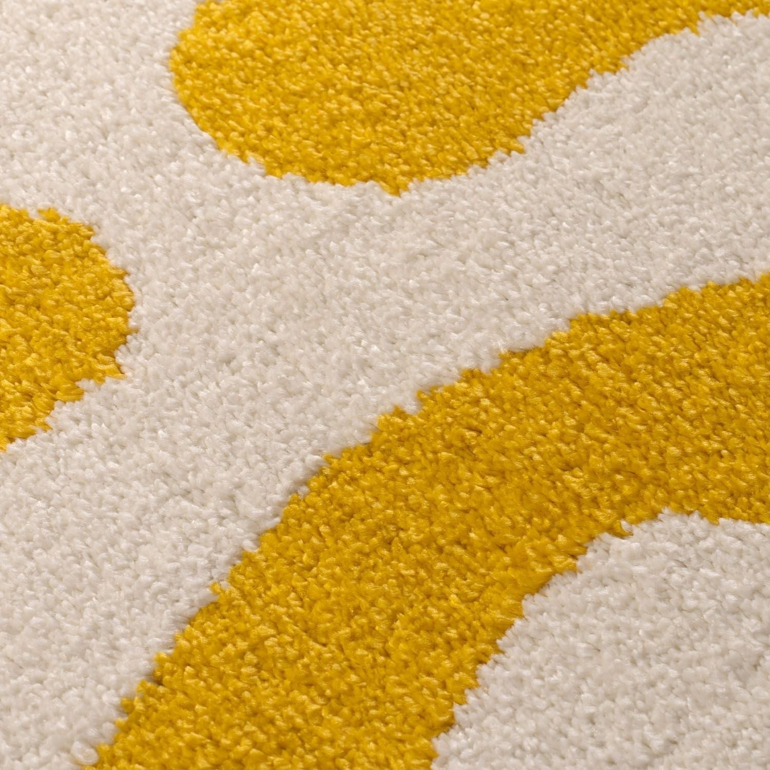 Close-up of a textured rug with yellow and white pattern