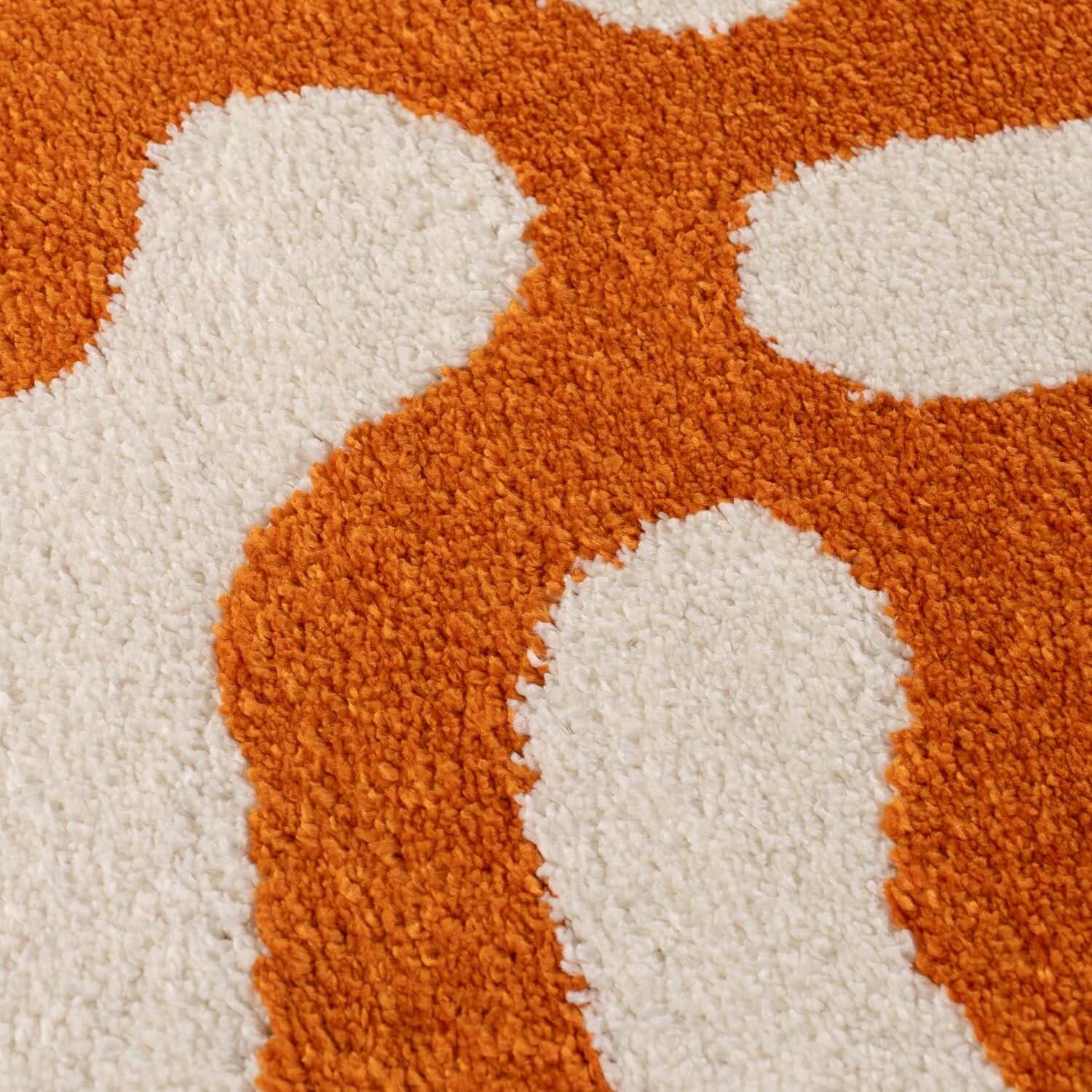 Close-up of a textured orange and white patterned rug