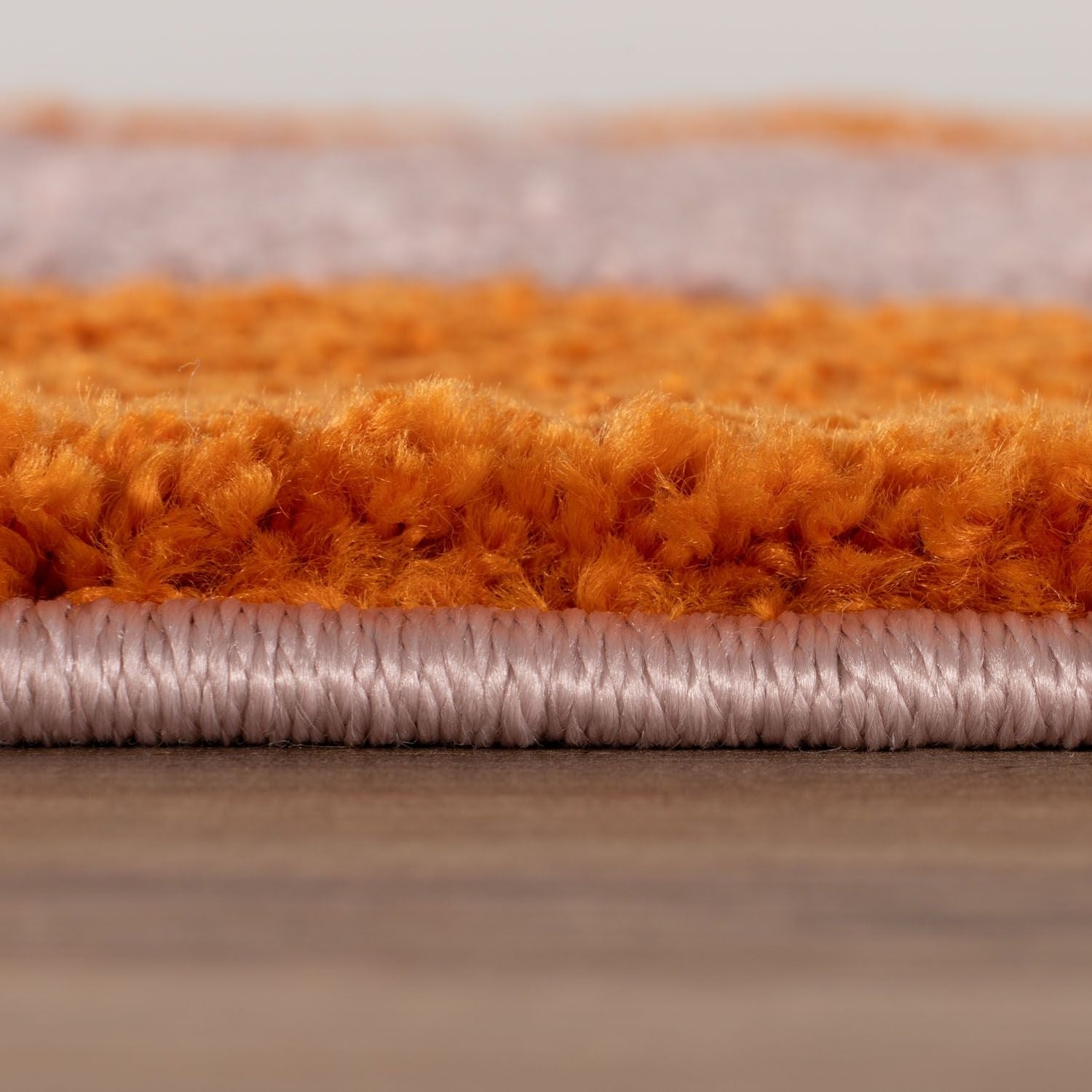 Close-up of orange and pink textured rug samples.