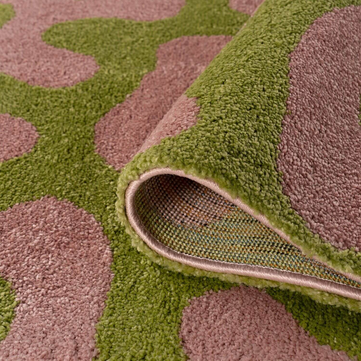 Close-up of a green and pink patterned rug.