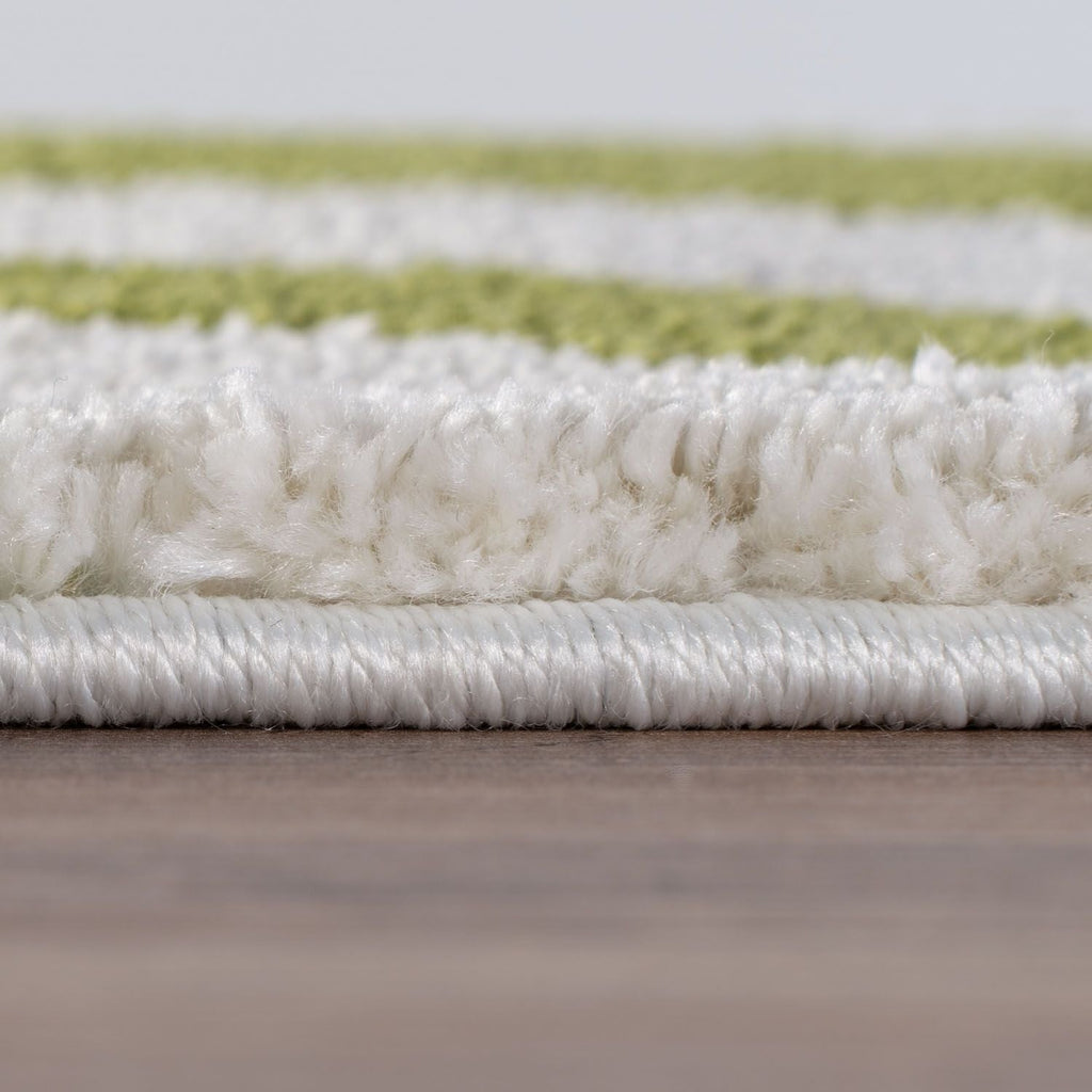 Close-up of a textured white and green rug on a wooden floor.
