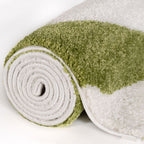 Green and white textured rug rolled up on a light background